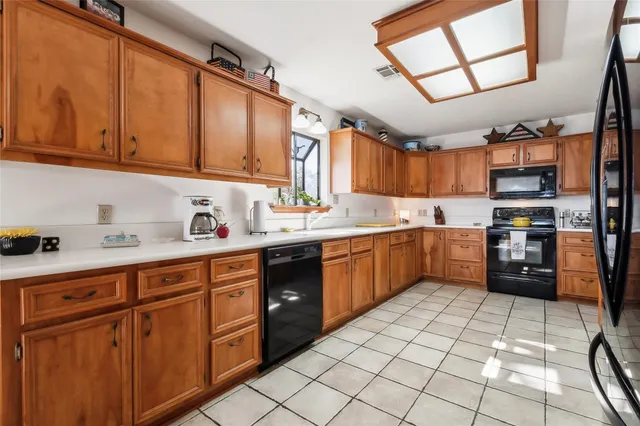 a kitchen with stainless steel appliances granite countertop a sink cabinets and a refrigerator