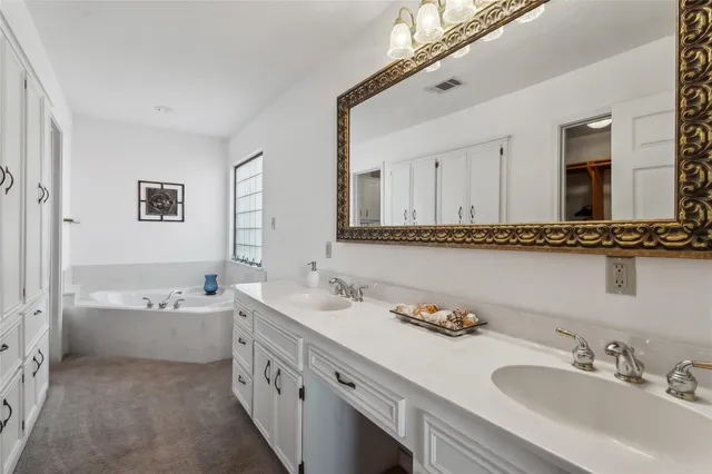 a bathroom with a double vanity sink double mirror and bathtub