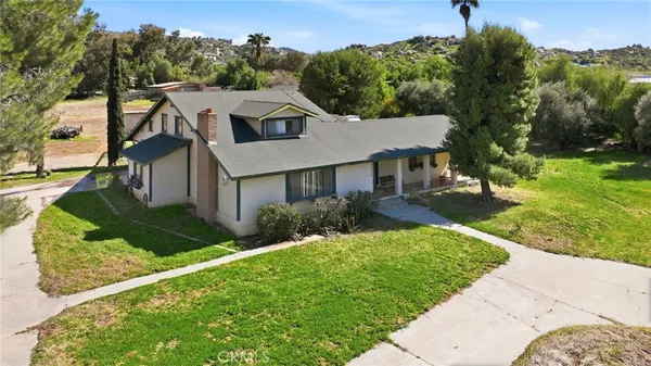 a aerial view of a house with a yard and potted plants