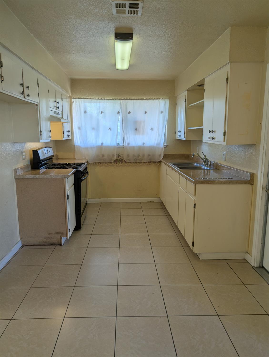 2228 Drake Avenue Merced, CA 95348 - Photo 6 of 24 a kitchen with stainless steel appliances granite countertop a stove a sink and a refrigerator