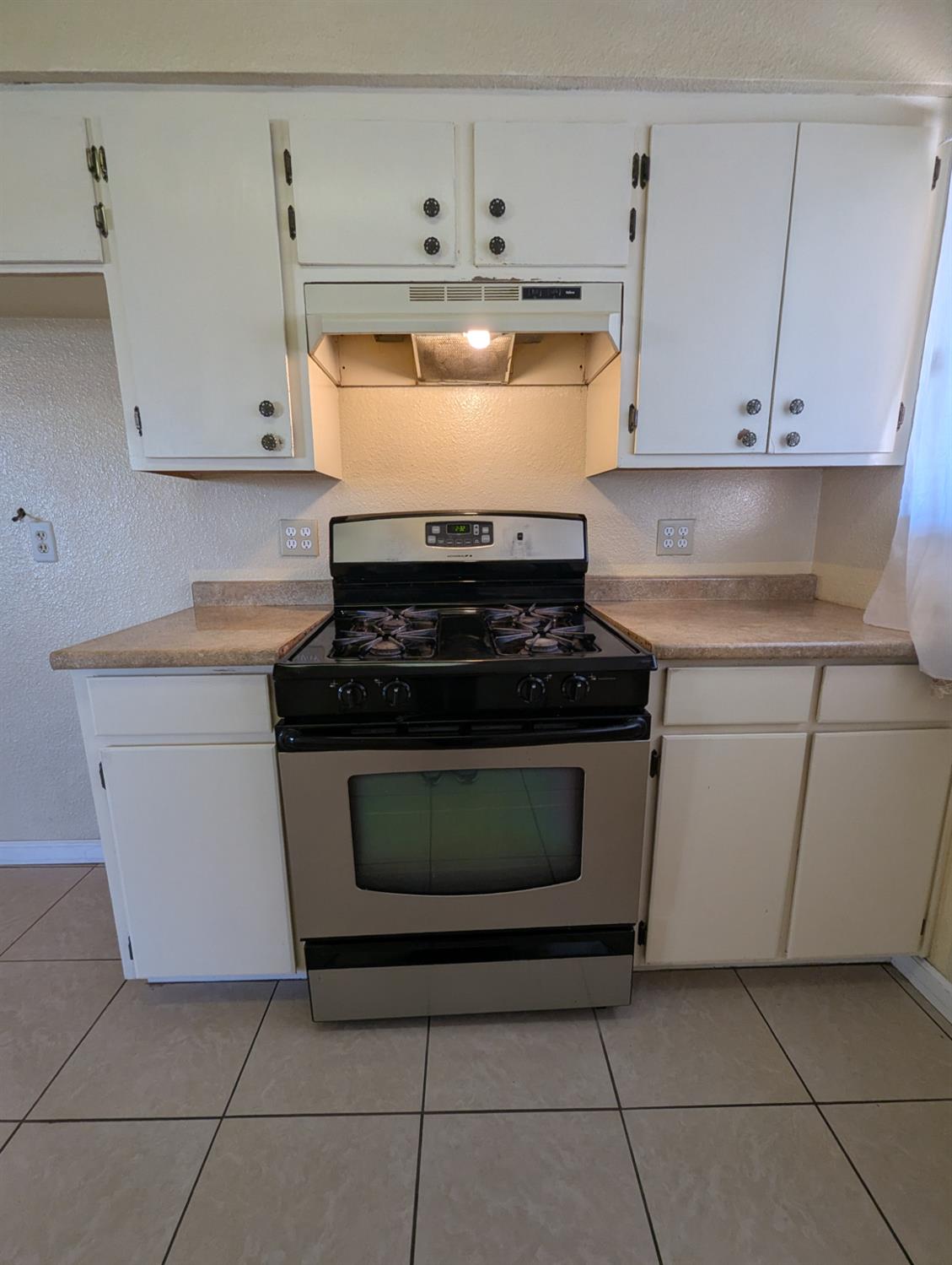 2228 Drake Avenue Merced, CA 95348 - Photo 7 of 24 a stove top oven sitting inside of a kitchen