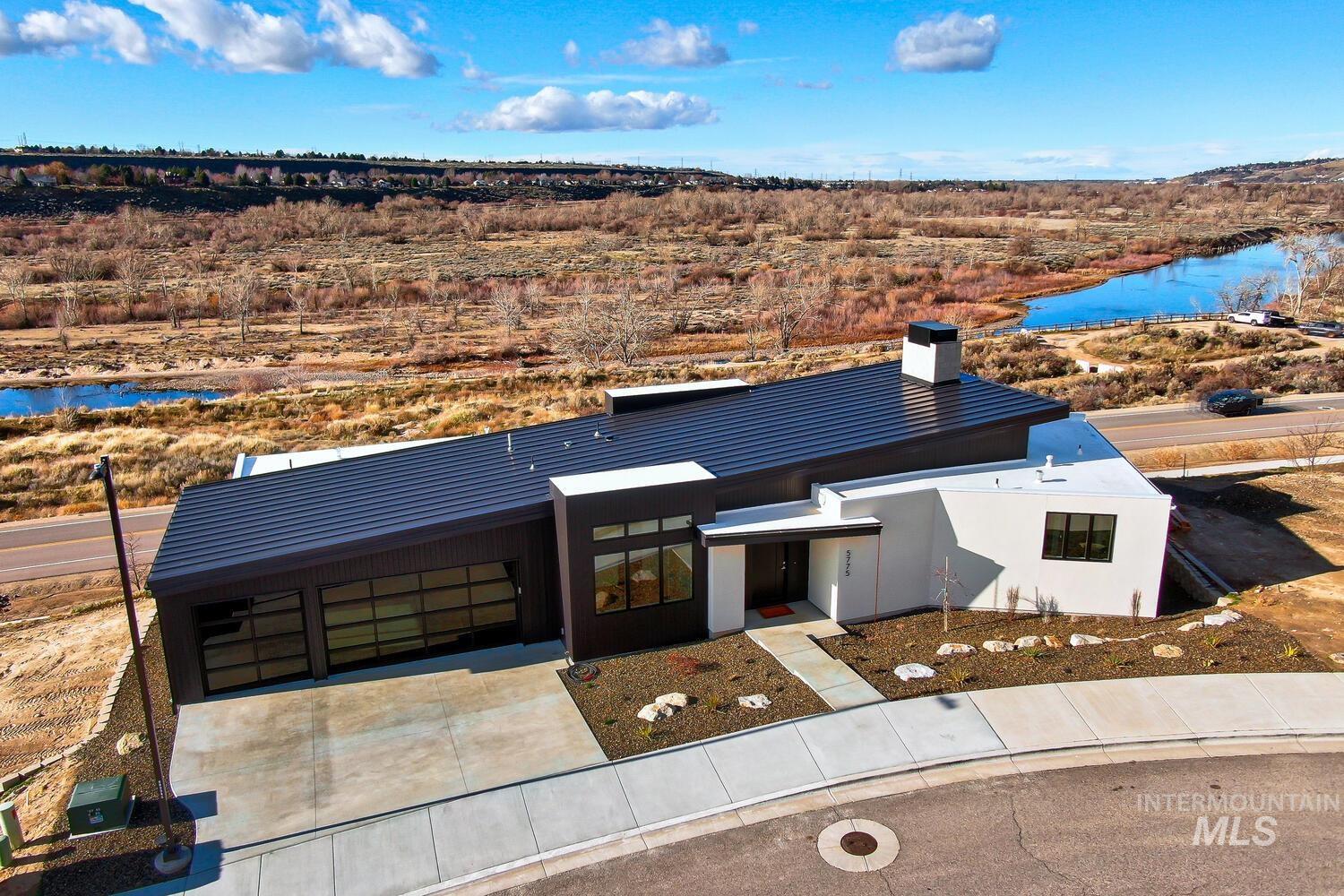 5775 South Brian Way Boise, ID 83716 - Photo 2 of 13 Contemporary home with a water view, a chimney, and concrete driveway