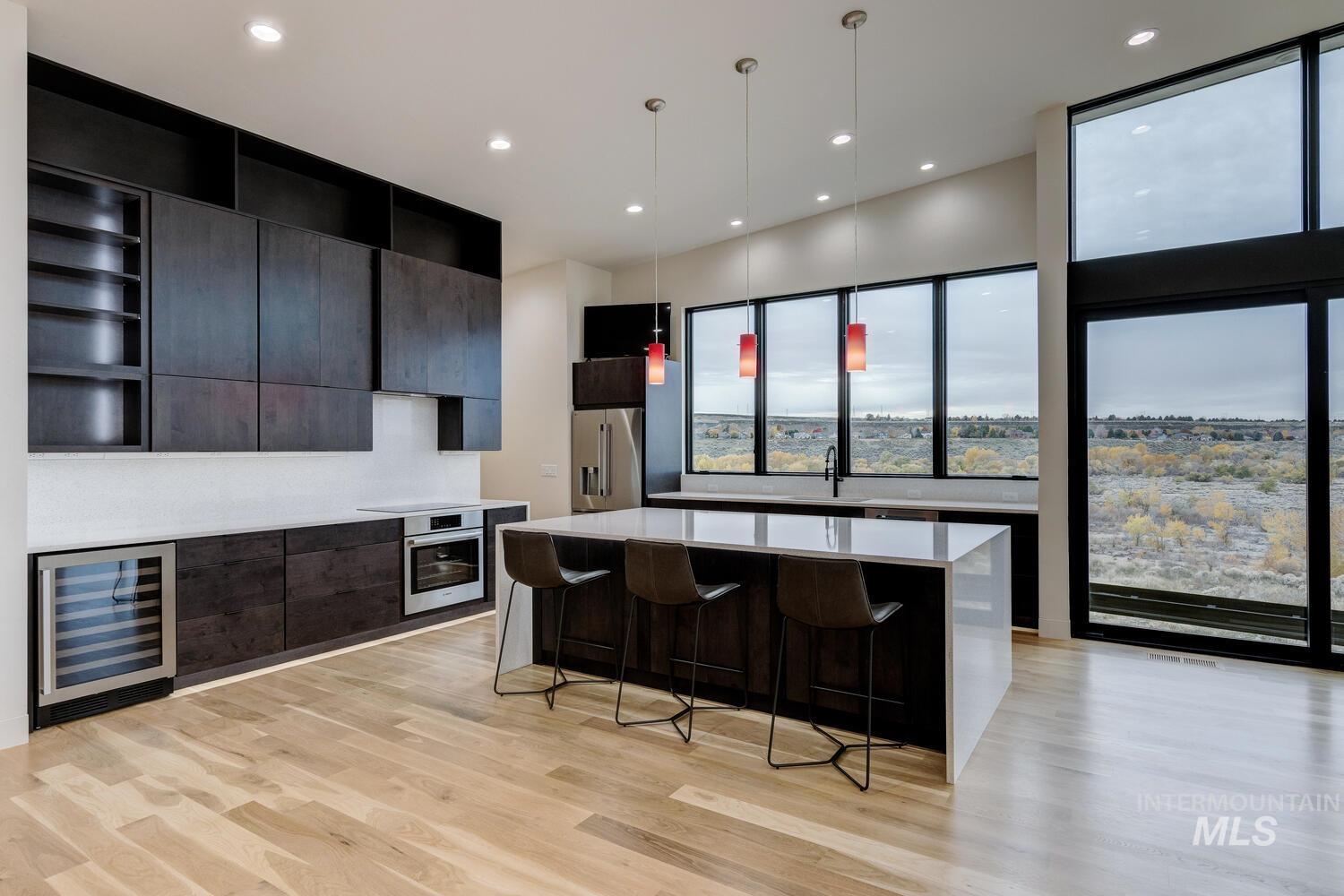 5775 South Brian Way Boise, ID 83716 - Photo 3 of 13 Kitchen with open shelves, pendant lighting, modern cabinets, beverage cooler, and a kitchen island