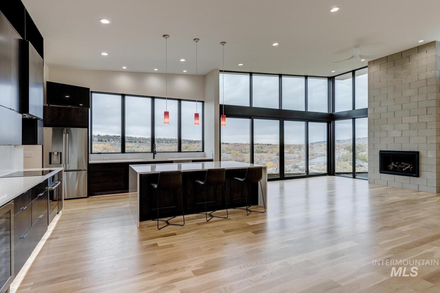 5775 South Brian Way Boise, ID 83716 - Photo 13 of 13 Kitchen with a kitchen breakfast bar, open floor plan, appliances with stainless steel finishes, dark cabinets, and floor to ceiling windows