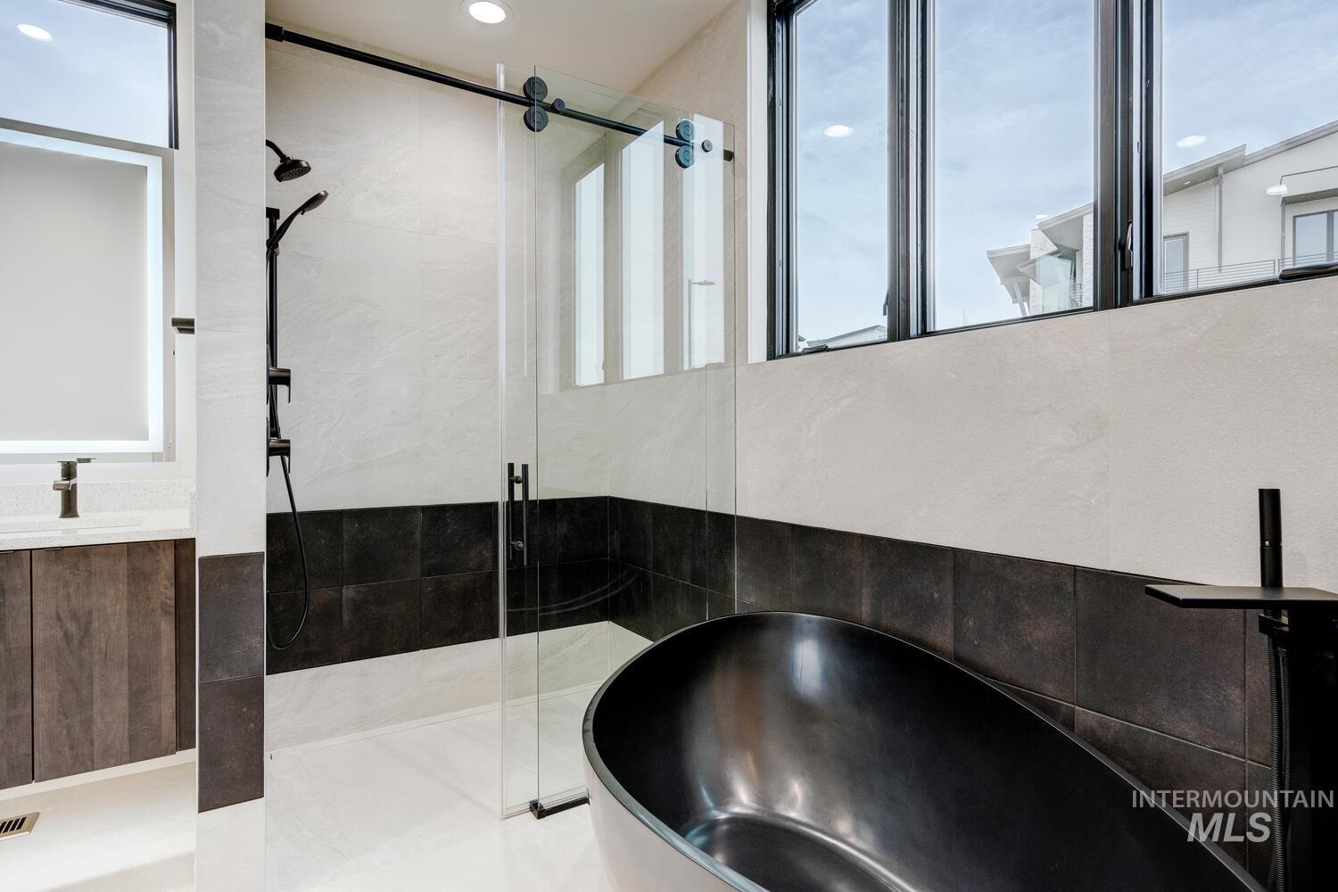 5775 South Brian Way Boise, ID 83716 - Photo 7 of 13 Full bathroom featuring a shower stall, a freestanding tub, vanity, and tile walls