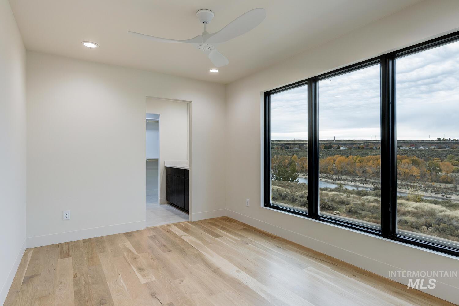5775 South Brian Way Boise, ID 83716 - Photo 8 of 13 Unfurnished room featuring recessed lighting, light wood-type flooring, ceiling fan, and a water view