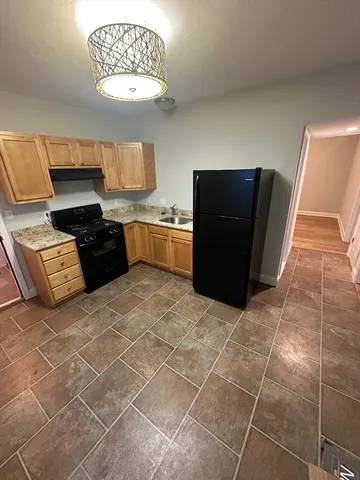 a kitchen with stainless steel appliances a counter space and wooden floor
