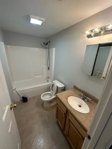a bathroom with a sink mirror vanity and toilet