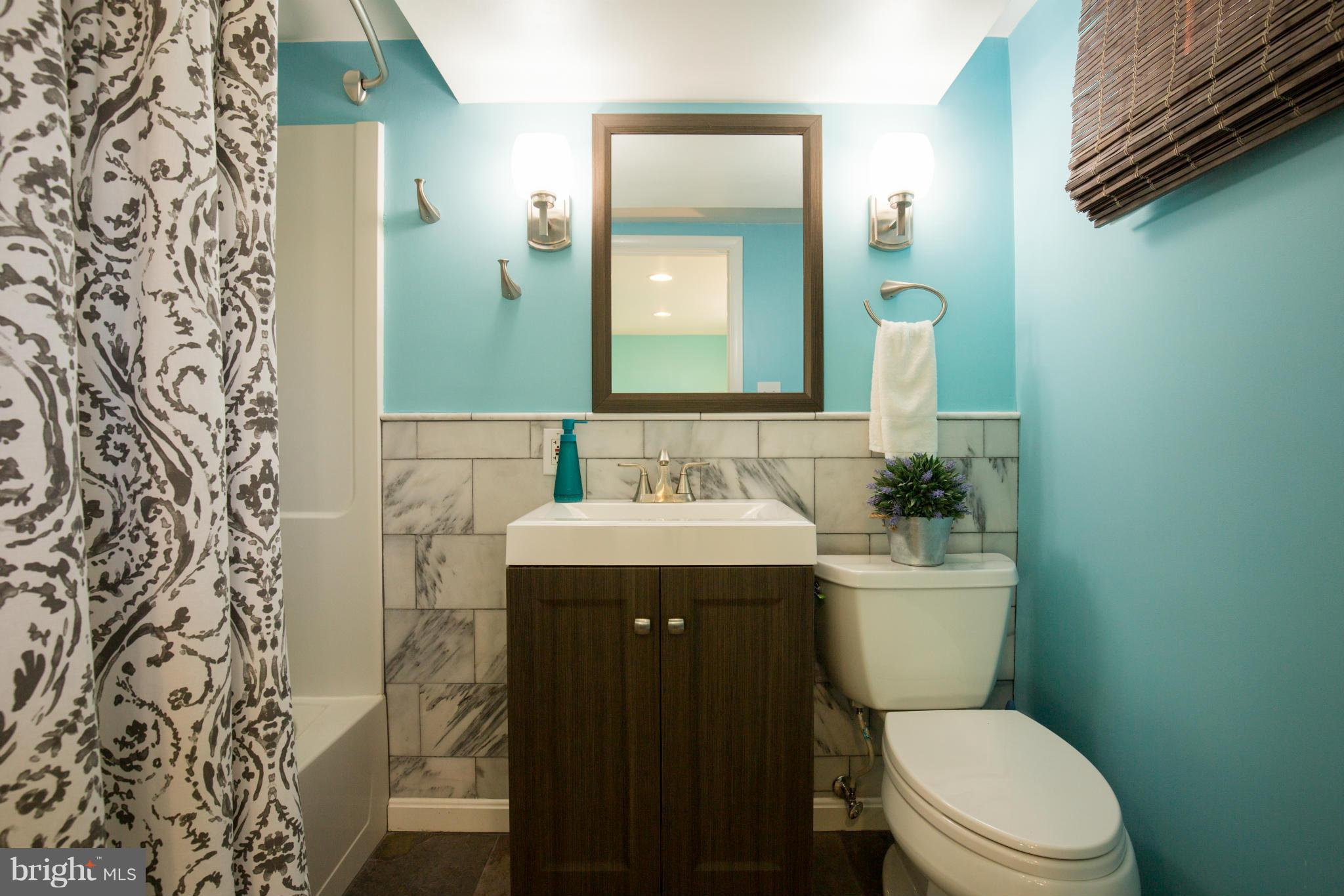 12716 Feldon Street Silver Spring, MD 20906 - Photo 26 of 30 a bathroom with a granite countertop toilet sink and mirror