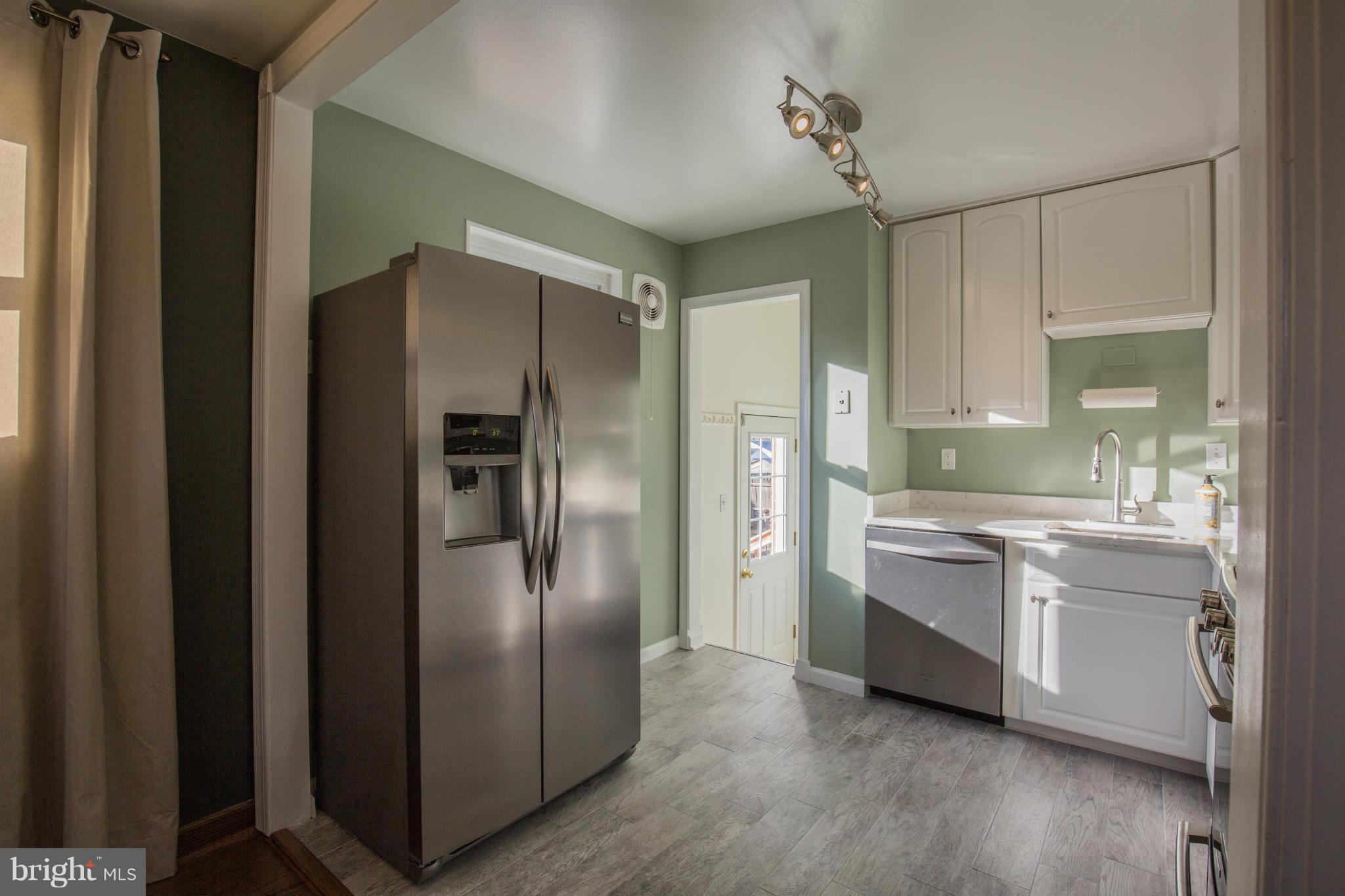 12716 Feldon Street Silver Spring, MD 20906 - Photo 7 of 30 a kitchen with stainless steel appliances granite countertop a refrigerator and a sink