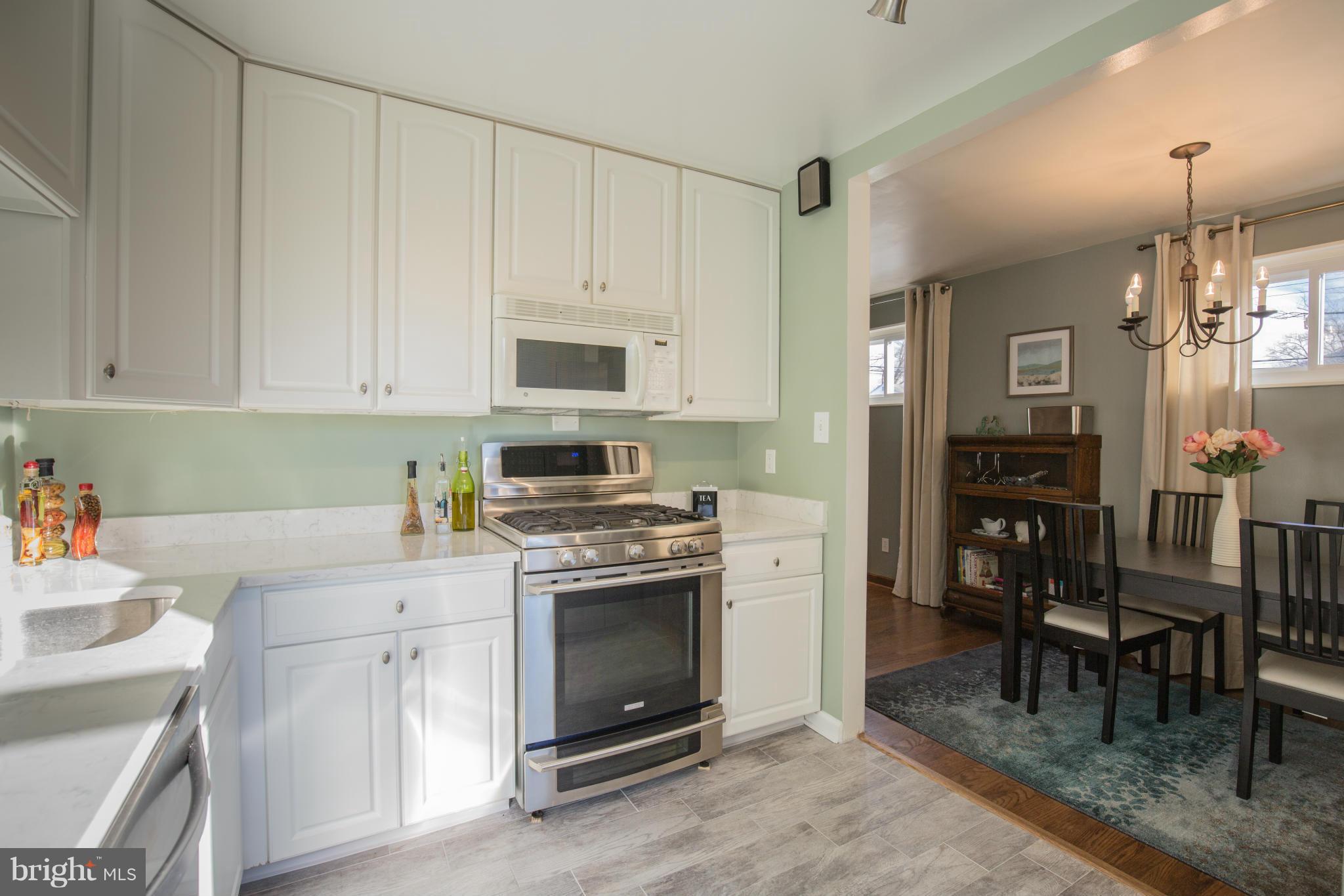 12716 Feldon Street Silver Spring, MD 20906 - Photo 9 of 30 a kitchen with cabinets appliances and a dining table