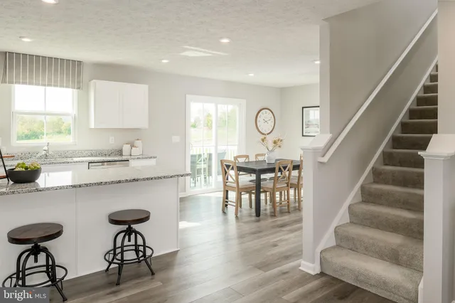 a kitchen with granite countertop white cabinets and stainless steel appliances