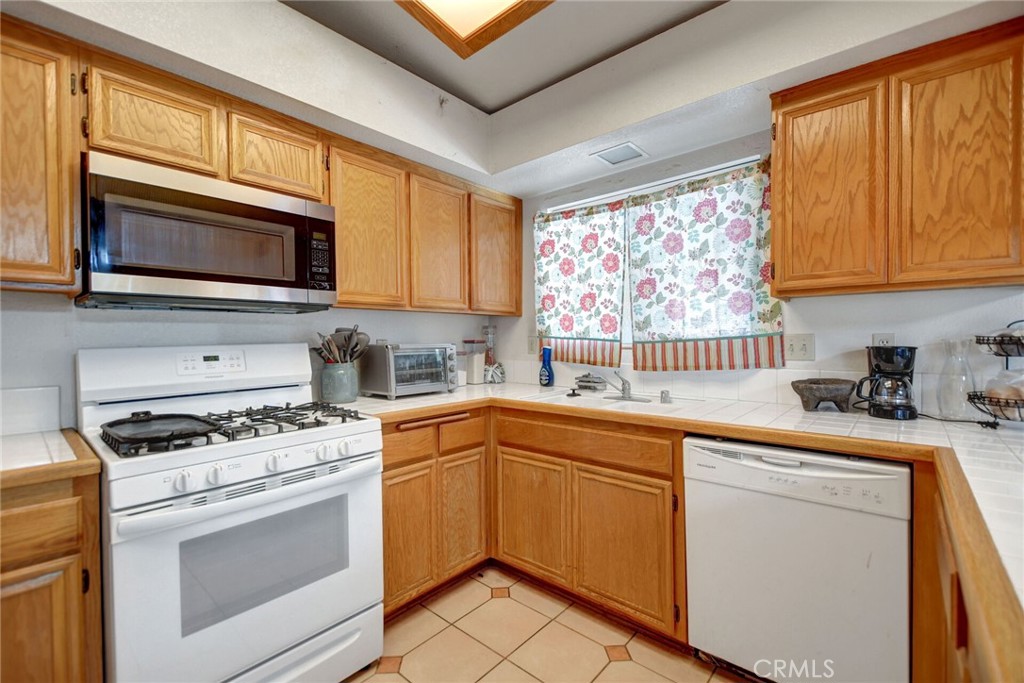 24880 Balestrieri Road Hemet, CA 92544 - Photo 11 of 34 a kitchen with cabinets appliances and a window