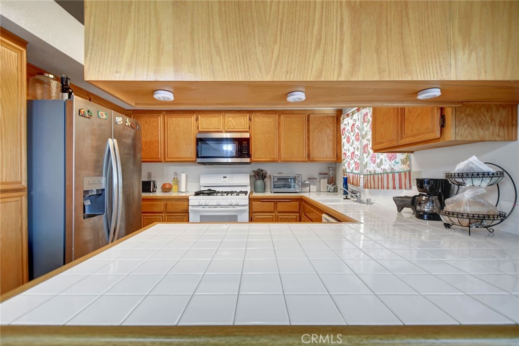24880 Balestrieri Road Hemet, CA 92544 - Photo 12 of 34 a kitchen with stainless steel appliances a stove a sink and a microwave
