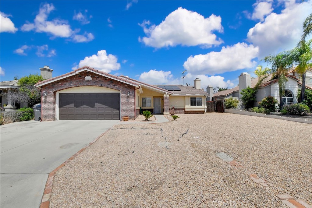 24880 Balestrieri Road Hemet, CA 92544 - Photo 2 of 34 a front view of a house with a yard and garage