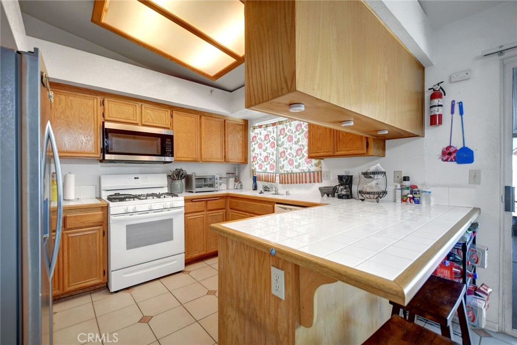 24880 Balestrieri Road Hemet, CA 92544 - Photo 10 of 34 a kitchen with a stove a sink and a refrigerator