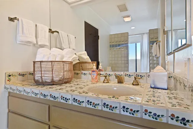 a bathroom with a granite countertop sink and a mirror