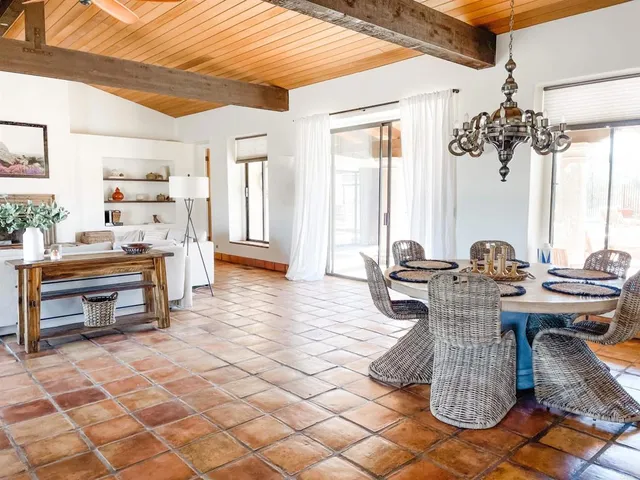 a dining hall with couches a flat screen tv and fireplace