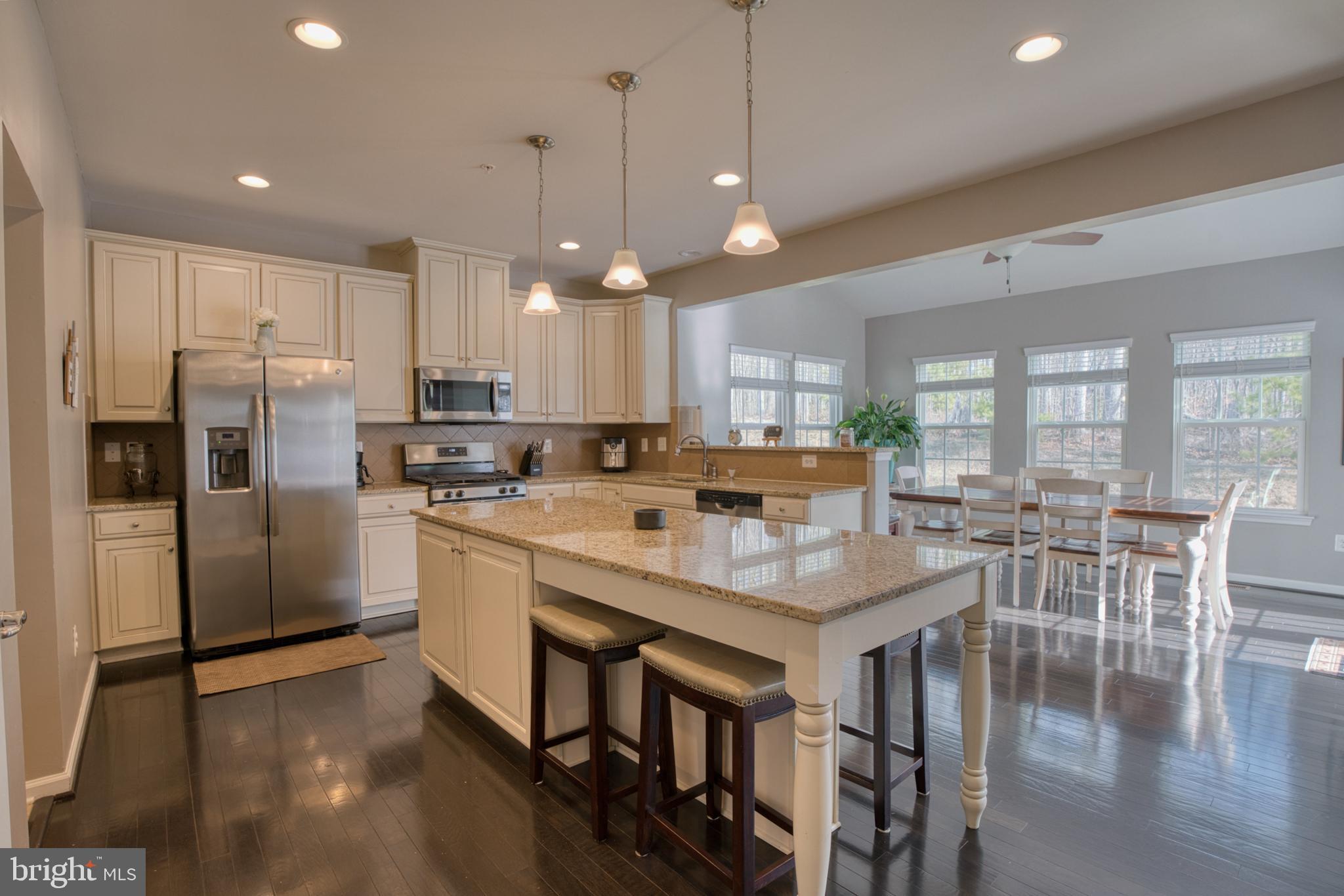 505 Potomac Road Joppa, MD 21085 - Photo 19 of 66 a kitchen with stainless steel appliances granite countertop a refrigerator a stove a sink a dining table and chairs with wooden floor