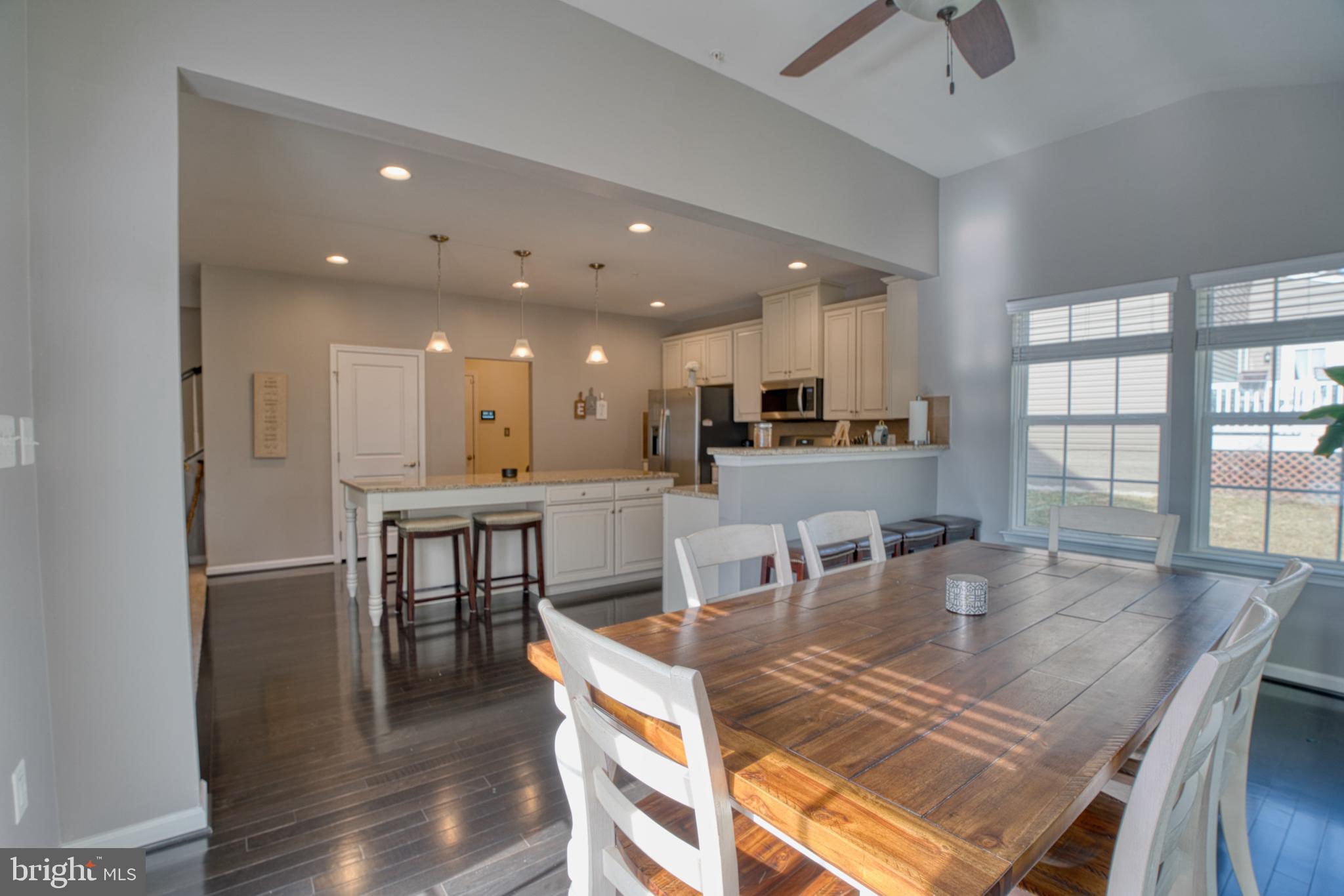 505 Potomac Road Joppa, MD 21085 - Photo 21 of 66 a dining room with kitchen island stainless steel appliances furniture large window and wooden floor