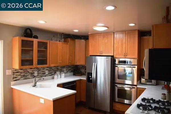 a kitchen with stainless steel appliances granite countertop a sink stove and refrigerator