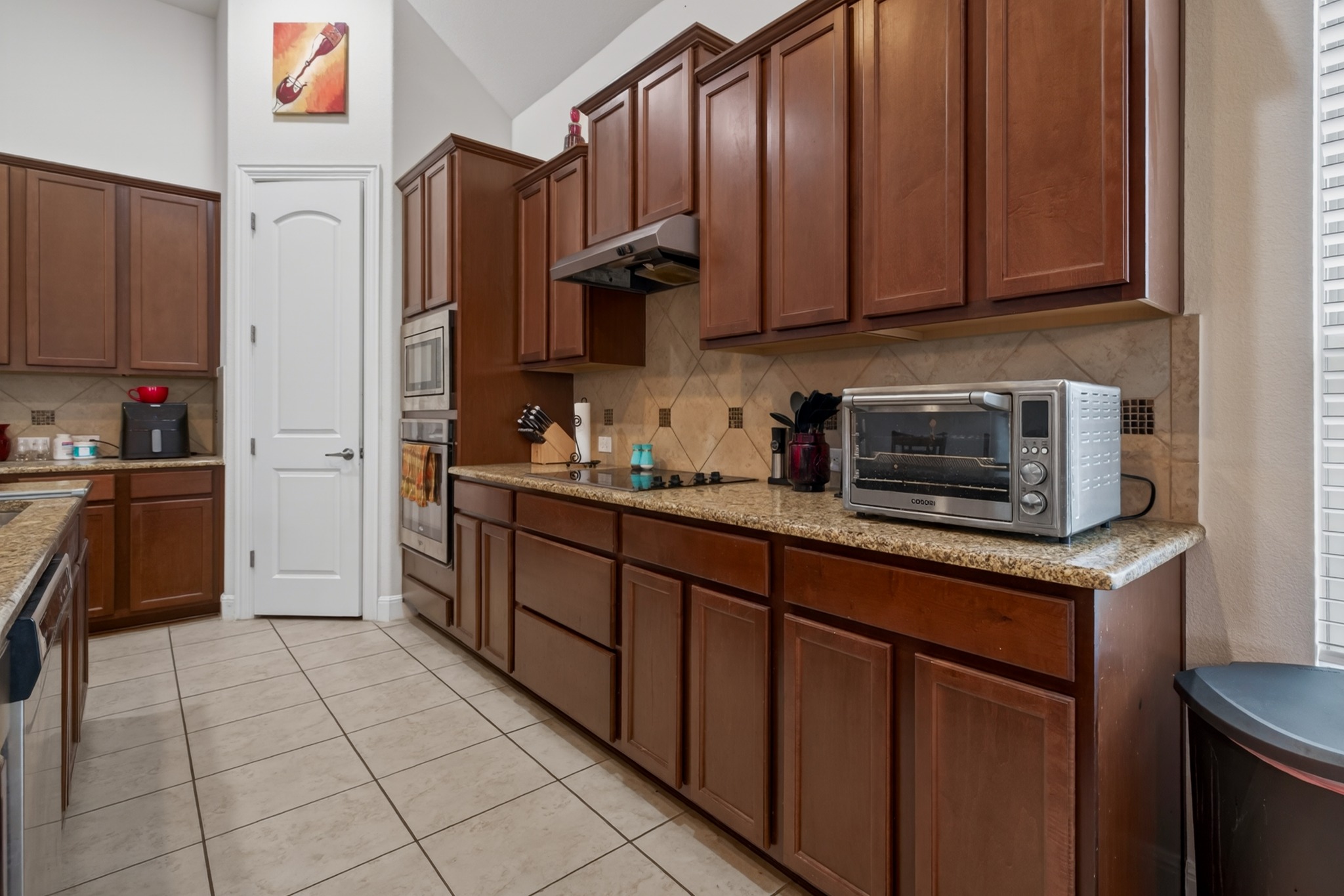 1017 Tabernash Leander, TX 78641 - Photo 13 of 38 Kitchen featuring extensive wood cabinetry, granite countertops, tile backsplash, built-in double oven, and a built-in range hood