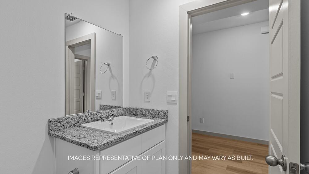 7339 9th Street Lubbock, TX 79416 - Photo 22 of 26 a bathroom with a granite countertop sink and a mirror