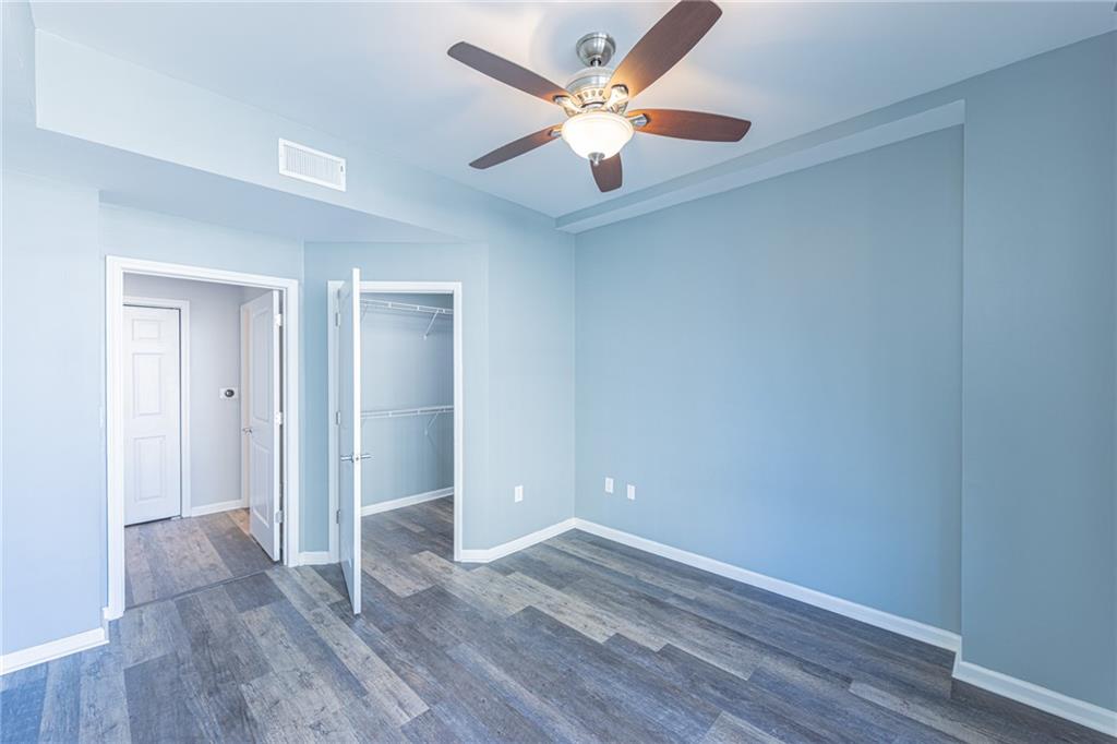 3040 Peachtree Road Northwest, Unit 613 Atlanta, GA 30305 - Photo 11 of 30 an empty room with wooden floor and ceiling fan