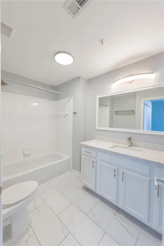 a bathroom with a tub sink mirror and a toilet