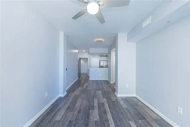 a view of a big room with wooden floor and a chandelier fan