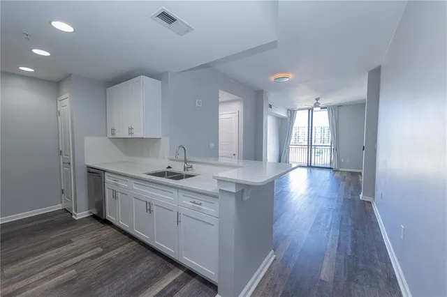 a kitchen with stainless steel appliances granite countertop a sink stove and wooden floor