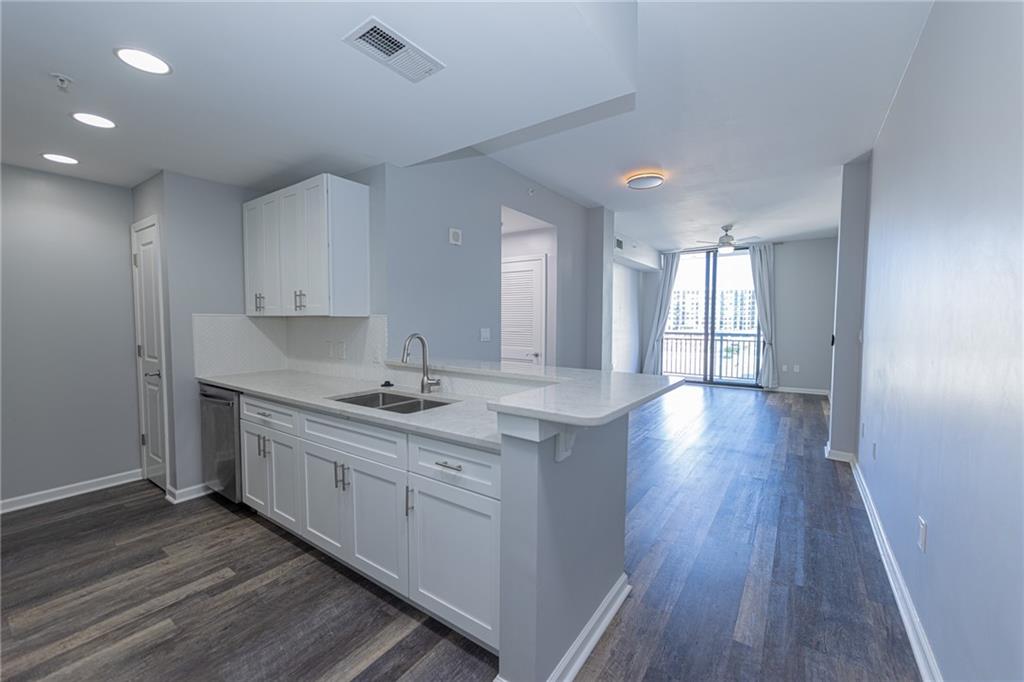 3040 Peachtree Road Northwest, Unit 613 Atlanta, GA 30305 - Photo 5 of 30 a kitchen with stainless steel appliances granite countertop a sink stove and wooden floor