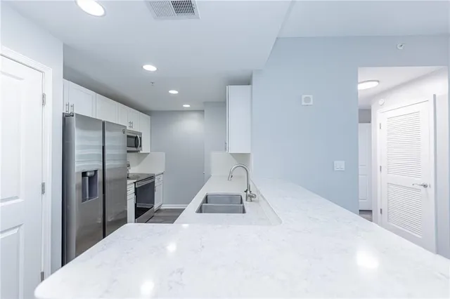 a room with a bed and a view of living room