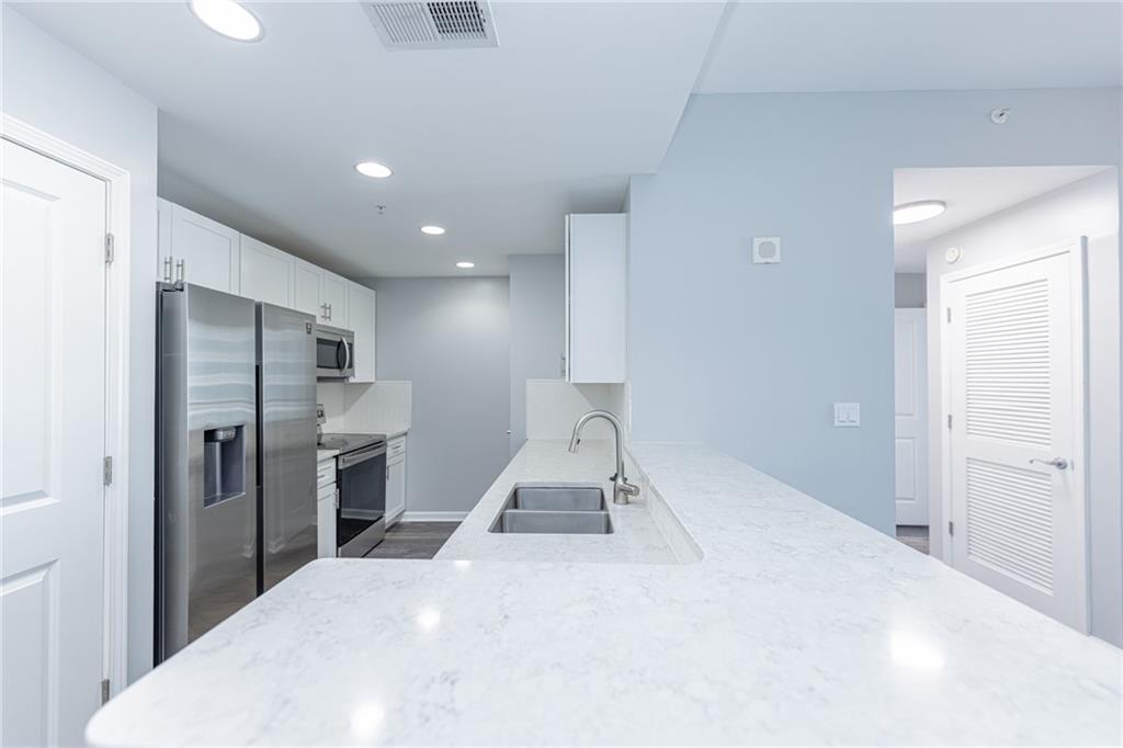 3040 Peachtree Road Northwest, Unit 613 Atlanta, GA 30305 - Photo 6 of 30 a room with a bed and a view of living room