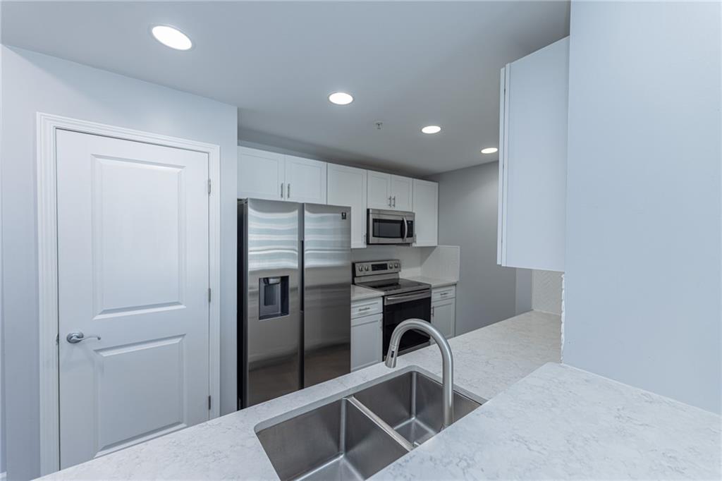 3040 Peachtree Road Northwest, Unit 613 Atlanta, GA 30305 - Photo 7 of 30 a kitchen with stainless steel appliances a refrigerator and microwave