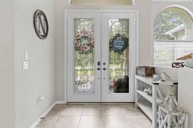 a view of a hallway with windows and chandelier