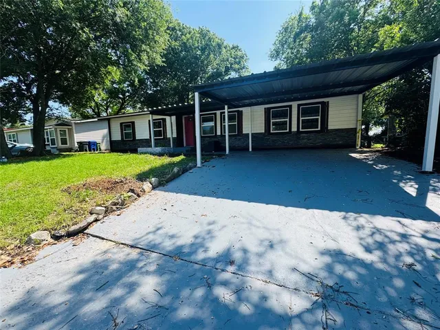 a front view of a house with a yard and trees