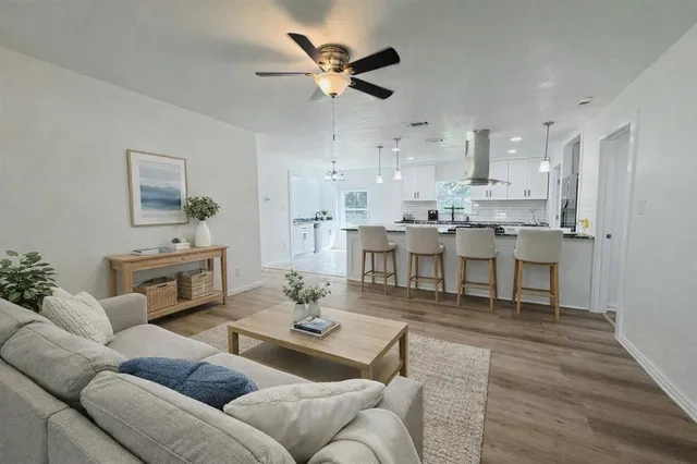 a living room with furniture kitchen view and a chandelier