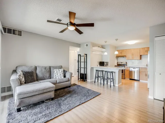 a living room with furniture and kitchen view