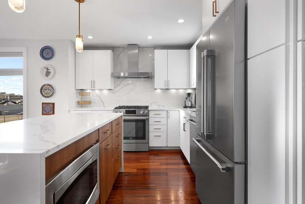 112 West 9th Street, Unit PH4 Boston, MA 02127 - Photo 4 of 34 a kitchen with stainless steel appliances granite countertop a sink and a refrigerator