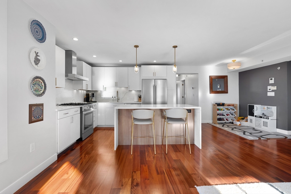 112 West 9th Street, Unit PH4 Boston, MA 02127 - Photo 5 of 34 a kitchen with stainless steel appliances granite countertop a refrigerator a stove top oven a sink dishwasher and white cabinets with wooden floor