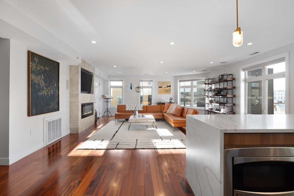 112 West 9th Street, Unit PH4 Boston, MA 02127 - Photo 6 of 34 a living room with stainless steel appliances furniture wooden floor and a kitchen view
