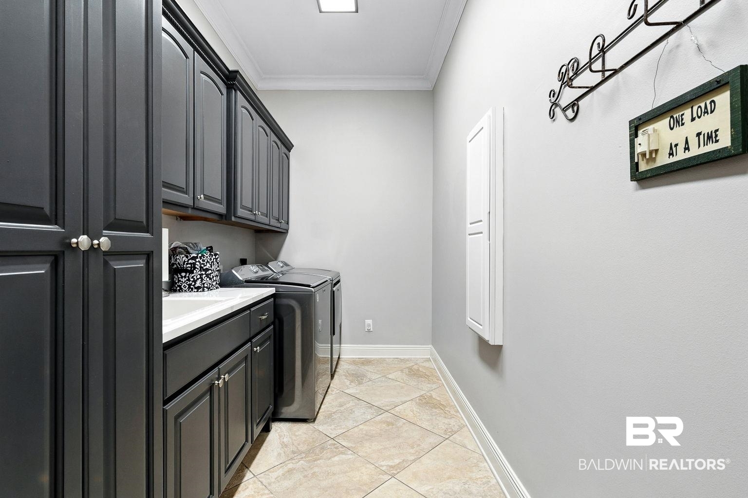 23357 Carnoustie Drive Foley, AL 36535 - Photo 72 of 99 Laundry room featuring cabinet space, washer and dryer, crown molding, and light tile patterned floors