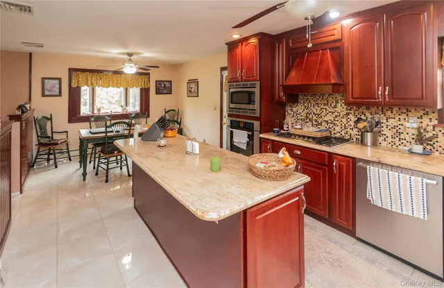 a kitchen with stainless steel appliances granite countertop a sink a stove and a wooden floor