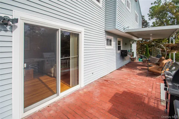 a patio with table and chairs and potted plants