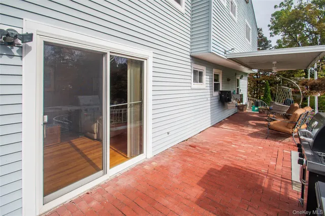 a patio with table and chairs and potted plants