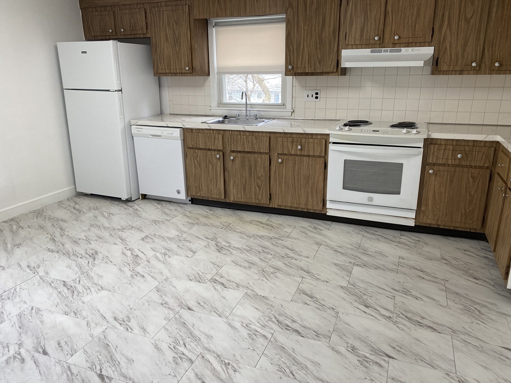 a kitchen with a sink a stove and a refrigerator