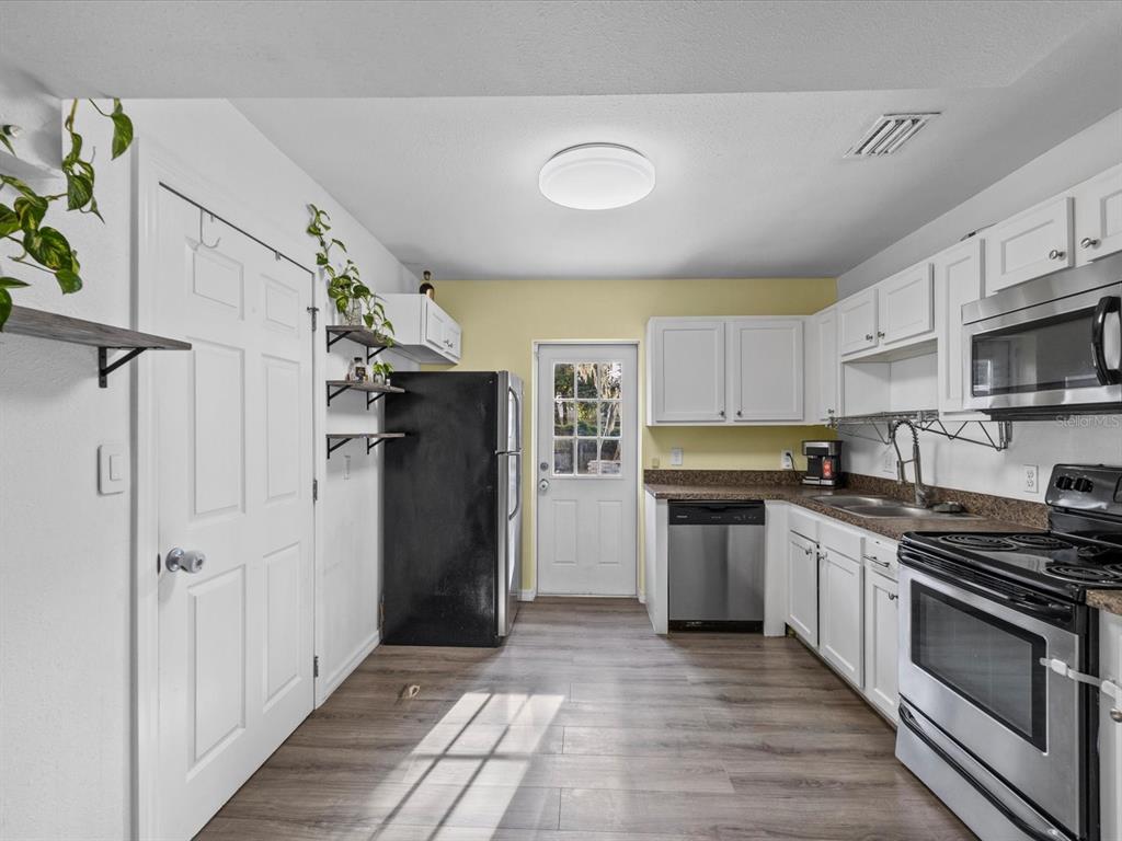 7114 Carlow Street New Port Richey, FL 34653 - Photo 11 of 65 a kitchen with stainless steel appliances granite countertop a refrigerator and a stove top oven
