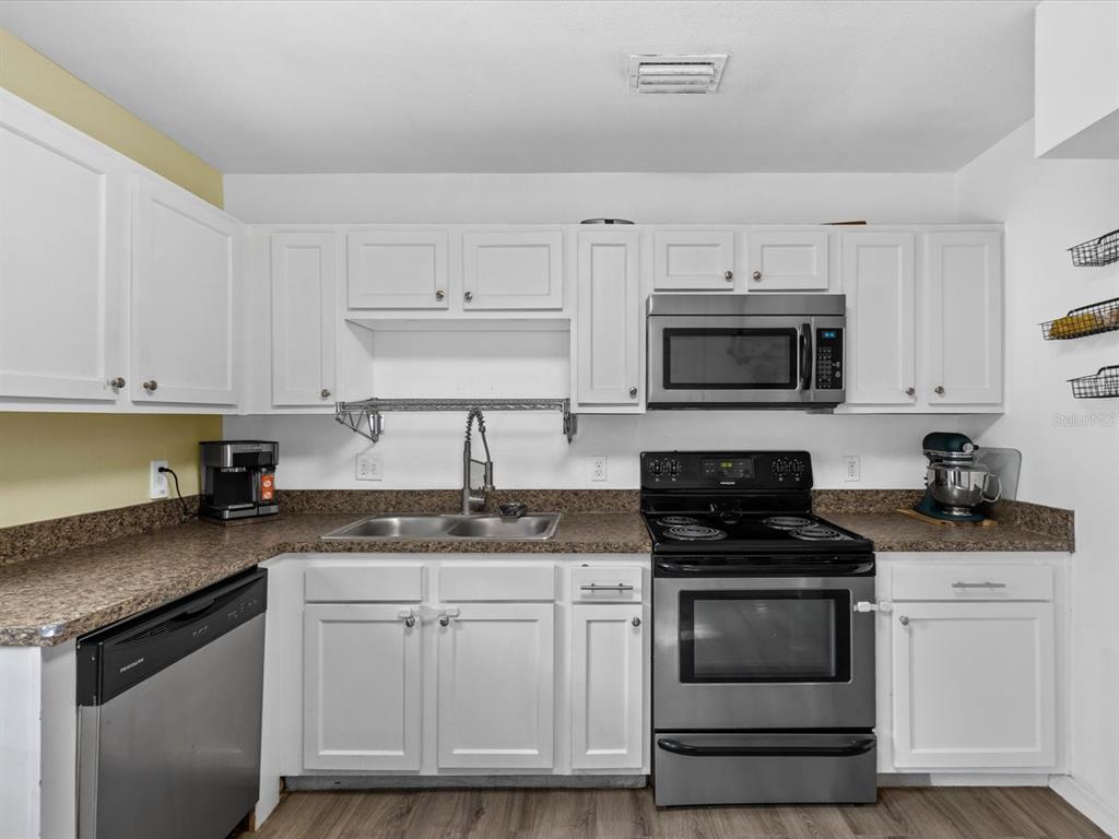 7114 Carlow Street New Port Richey, FL 34653 - Photo 13 of 65 a kitchen with granite countertop white cabinets white stainless steel appliances and a sink