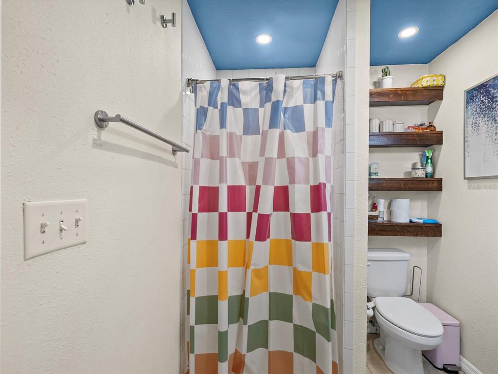 7114 Carlow Street New Port Richey, FL 34653 - Photo 19 of 65 a bathroom with a shower curtain and a toilet